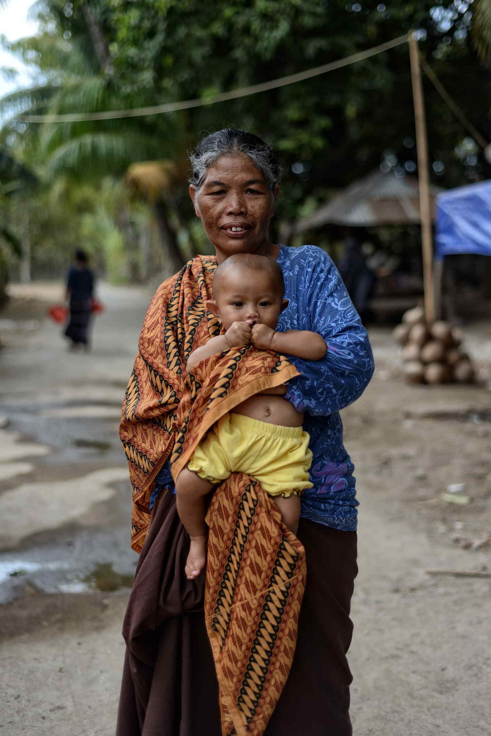 Elderly woman with child in her arms. Picture was taken in one of the refugee camps after an earthquake hit northern lombok